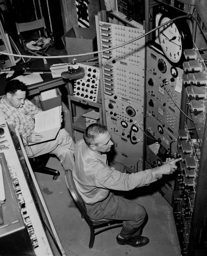 010925_ec_neutrino_inline Two men monitor controls at a nuclear reactor.